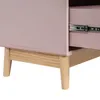 Close-up view of the lower part of a pink dresser with wooden legs and a visible drawer slide. Podgląd zdjęcia produktu
