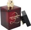 A red glass perfume bottle with a gold cap and a black cap lying next to it. Podgląd zdjęcia produktu
