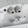 Close-up view of the internal components of a white electrical enclosure, showing cable glands and mounting clips. Náhľad obrázku produktu