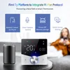 A smart thermostat is shown with a smart speaker and a person using a phone in the background, highlighting its features. Podgląd zdjęcia produktu
