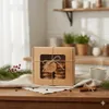 A box of cookies is displayed on a wooden table, with a cup of coffee and Christmas decorations in the background. Náhľad obrázku produktu