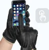A person wearing black leather gloves is using a smartphone. Produktbild-Vorschau