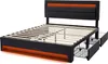 A black upholstered bed frame with orange LED lighting and four storage drawers pulled out. Podgląd zdjęcia produktu