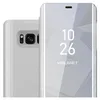 A close-up of a silver smartphone case with a transparent front cover displaying the time and date. Náhľad obrázku produktu