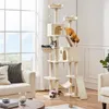 A tall, multi-level cat tree with several cats interacting with it, placed in a well-lit living room with a large window and furniture. Podgląd zdjęcia produktu