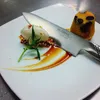 A close-up of a dessert with a knife resting on it. Anteprima dell’immagine prodotto