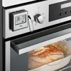 A close-up shot of a digital thermometer probe inserted into a roast chicken in an oven. Anteprima dell’immagine prodotto