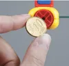 A hand holding a 10 Euro cent coin in front of a yellow and red tool. Produktbild-Vorschau