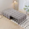 A gray tufted daybed is shown in a well-lit room with a patterned rug and a floor lamp. Produktbild-Vorschau