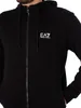 A close-up shot of a person wearing a black hooded jacket with a zipper. Produktbild-Vorschau