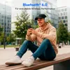 A man is sitting on a bench outdoors, looking at his phone and wearing headphones. Produktbild-Vorschau