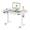A white standing desk with a computer monitor, keyboard, mouse, cup holder with a cup and pens, headphones, and a small fan. Voir les images du produit