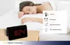 A woman sleeping in bed with a digital alarm clock on a nightstand. Anteprima dell’immagine prodotto