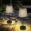 Two solar table lamps are placed on a stone pathway in a garden at night. Produktbild-Vorschau