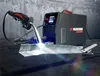 A welding machine is shown in operation, welding two metal pieces together. Produktbild-Vorschau