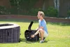 A man is setting up an inflatable hot tub in a backyard. Voir les images du produit