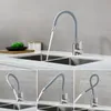 A kitchen faucet with a flexible gray hose is shown in various positions over a double sink. The top image shows water flowing from the faucet into the sink, while the bottom three images demonstrate the flexibility of the faucet's spout. Produktbild-Vorschau