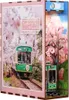 A diorama-style product depicting a train traveling through a cherry blossom forest, with a smaller train model on the side. Voir les images du produit