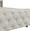 Close-up view of the tufted headboard of a beige upholstered bed frame with nailhead trim. Náhľad obrázku produktu