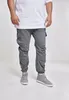 A person wearing grey cargo jogging pants and grey high-top sneakers, standing against a white background. Produktbild-Vorschau
