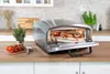 Der Unold Pizzaofen Enzo, ein Tischbackofen aus Edelstahl, zeigt bei geöffneter Tür eine frisch geba Produktbild-Vorschau
