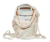 A white appliance is partially enclosed in a beige drawstring bag. Produktbild-Vorschau