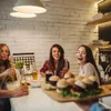 A group of friends enjoying food and drinks at a table. Voir les images du produit