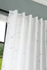 A close-up view of white curtains with a subtle pattern of stars and moons. Produktbild-Vorschau