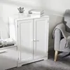 A white cabinet with double doors is shown in a room with a gray armchair and a rug. Produktbild-Vorschau