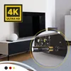 A close-up view of the back of a TV or media device, showing various ports and a cable being plugged in, with a larger view of a living room setup in the background. Produktbild-Vorschau