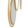 A close-up, side view of a decorative wall mirror with a gold metal frame and multiple circular mirrors. Produktbild-Vorschau