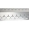 A close-up, angled view of a stainless steel burner cover with multiple T-shaped cutouts and a flame logo. Produktbild-Vorschau