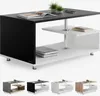 A modern coffee table with a black top and white lower shelves, shown from a slightly elevated angle. Produktbild-Vorschau