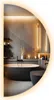 A modern bathroom with a freestanding bathtub and toilet, reflected in a large, illuminated, semi-circular mirror. Produktbild-Vorschau