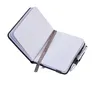 An open notebook with a pen attached to the side, set against a white background. Produktbild-Vorschau
