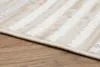 A close-up view of a rug with a striped pattern, placed on a wooden floor. Voir les images du produit