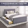 A grey upholstered bed with two pull-out drawers is shown in a bedroom setting. Produktbild-Vorschau