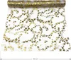 A roll of gold star-patterned table runner on a white background. Produktbild-Vorschau
