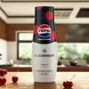 A bottle of Sodastream Pepsi Max Cherry syrup is placed on a wooden table in a kitchen setting, with cherries in the foreground. Produktbild-Vorschau