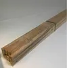 A stack of wooden planks tied together with a green band, lying on a white surface. Produktbild-Vorschau