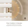 Close-up of a white electric towel warmer with a digital display and control buttons, overlaid with a graphic indicating a timer function. Produktbild-Vorschau
