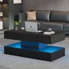 A modern living room with a black coffee table featuring LED lighting, a laptop, and a vase of plants. Produktbild-Vorschau