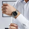 A man is adjusting his shirt cuff while wearing a watch. Náhled obrázku produktu