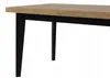 A close-up view of a table with a wooden top and black legs. Náhled obrázku produktu