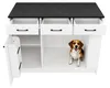 A white kitchen island with a black marble countertop, three open drawers, and an open cabinet with a beagle dog inside. Náhled obrázku produktu