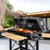 A person is grilling food on a charcoal grill outdoors. Náhľad obrázku produktu