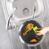 A person is cleaning a frying pan in a kitchen sink. Voir les images du produit