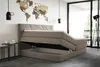 A bedroom scene featuring a large bed with its storage compartment open, a world map on the wall, and modern pendant lights. Voir les images du produit