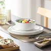 A table setting with a salad bowl, plates, a donut, and a glass of water. Náhled obrázku produktu