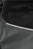 A close-up view of a pair of black and gray work pants, showing the fabric texture and a reflective stripe. Anteprima dell’immagine prodotto
